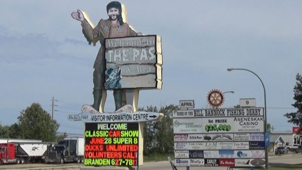 “Trapper’s signage cut in the shape of the trapper holding a “welcome to the Pas” sign. Secondary sign to the right with a logo at top. Link to video for description”