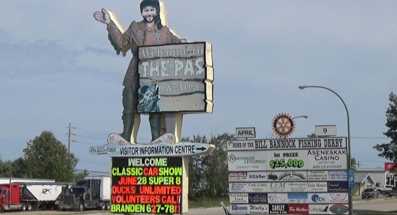 “Trapper’s signage cut in the shape of the trapper holding a “welcome to the Pas” sign. Secondary sign to the right with a logo at top. Link to video for description”