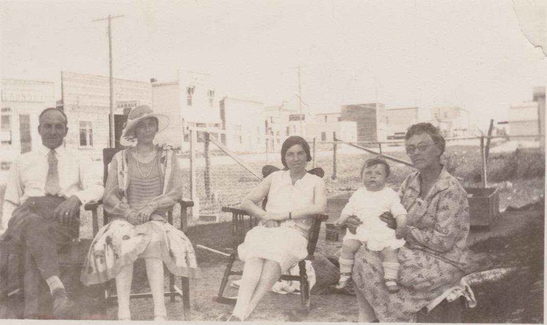 Charlie Krempeaux and Family sitting outside on the main street of The Pas likely during the warmer months.
