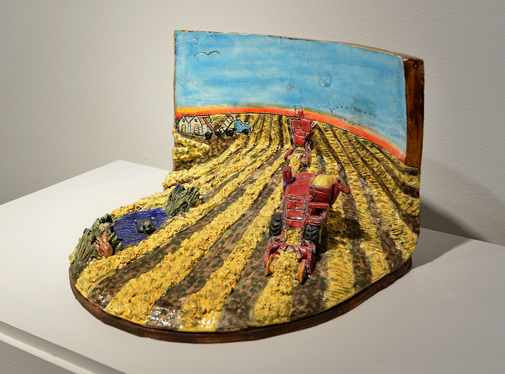 Diorama en céramique montrant un champ avec de l’équipement agricole