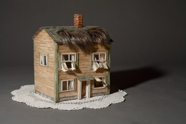 Sculpture of a house with a fringe of hair