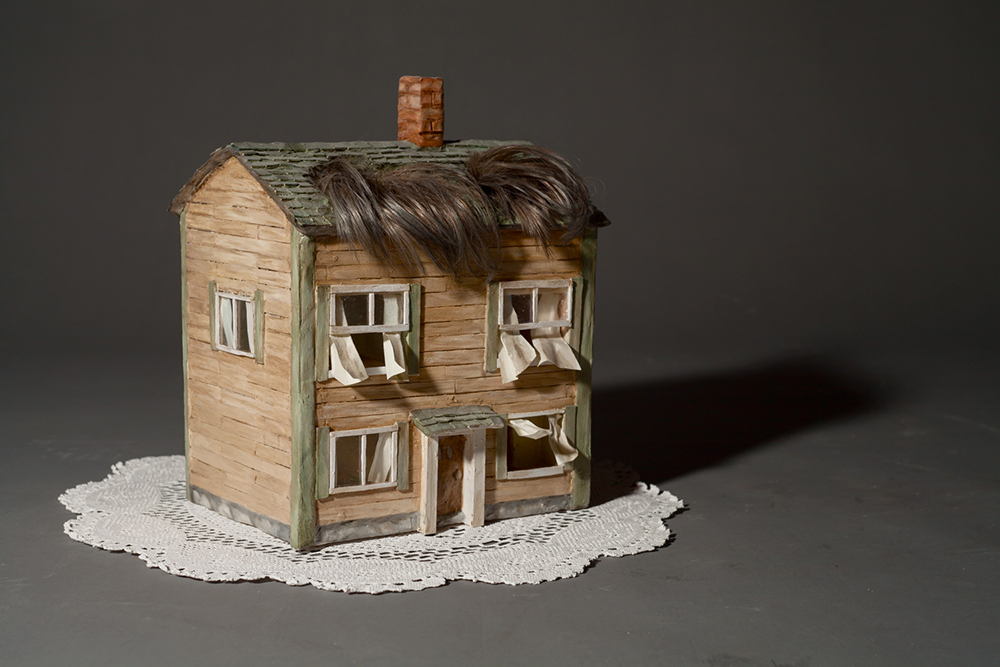 Sculpture d’une maison avec une frange de cheveux