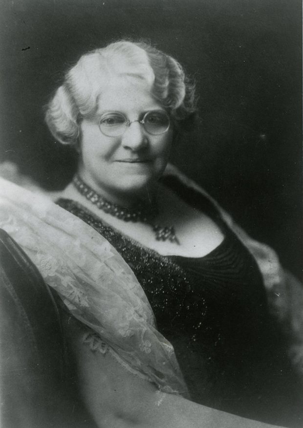 Black and white portrait of Mrs. Archibald Huestis who is elegantly dressed and looks towards the camera.