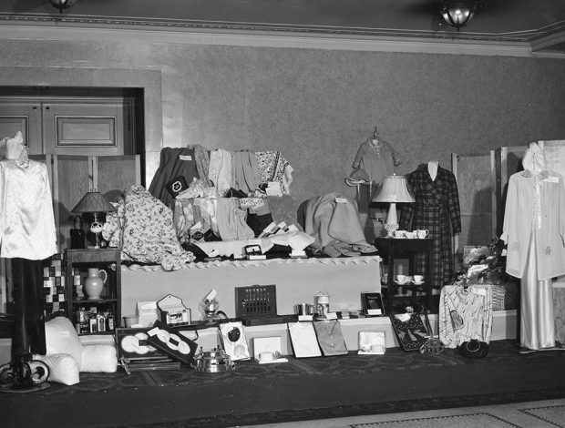 Domestic goods arranged on a stage in a black and white photo.