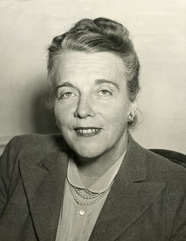 Black and white portrait of a smiling woman.