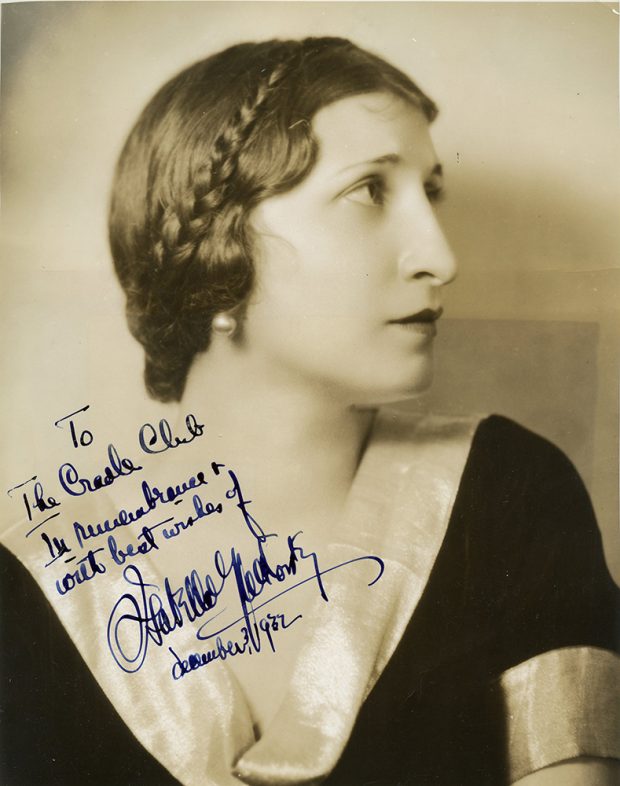 Black and white profile headshot of Isabelle Yalkovsky wearing a dark dress with light collar and pearl earrings.