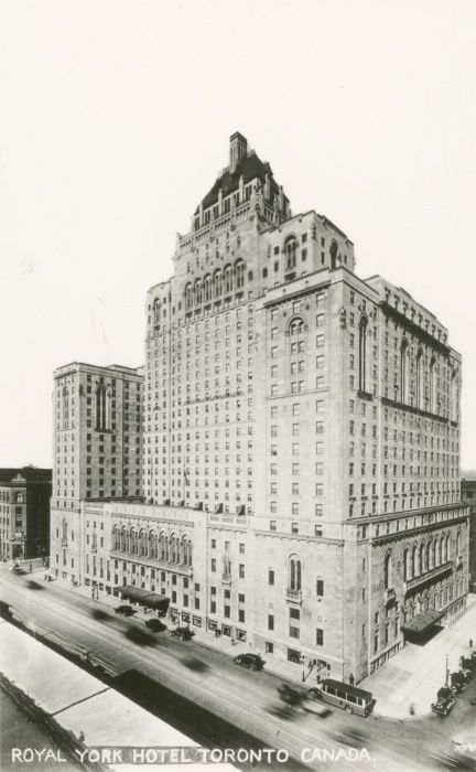 A black and white photo of the Royal York hotel with cars passing on the street below.