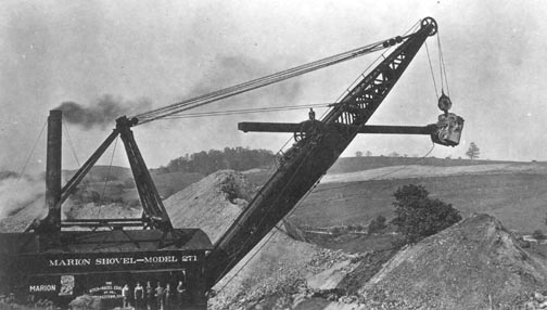 A steam shovel moving earth