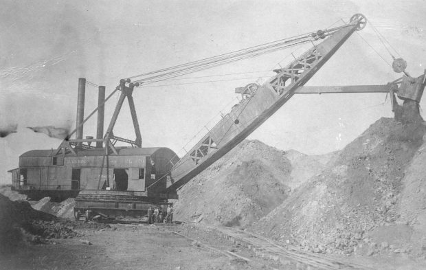 A steam shovel moves earth while building the Eastern Railway