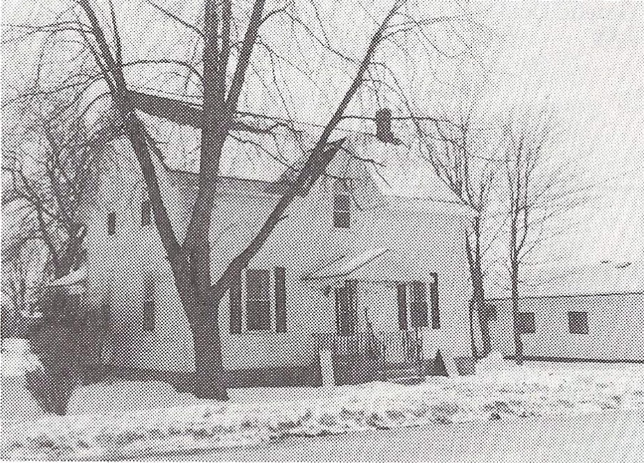 Black and white photograph of a small, two-storey white house in winter at 235 Ottawa Street in Almonte.
