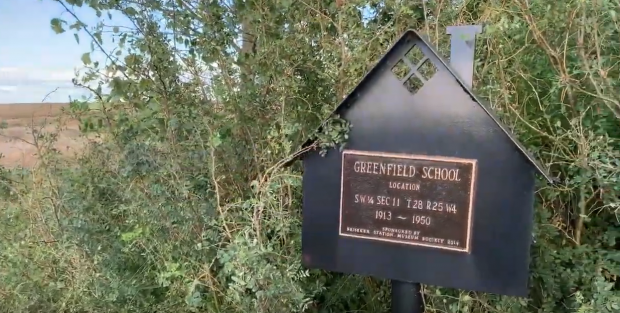 Sign in shrubs marking site of Greenfield School, 1913-1950.