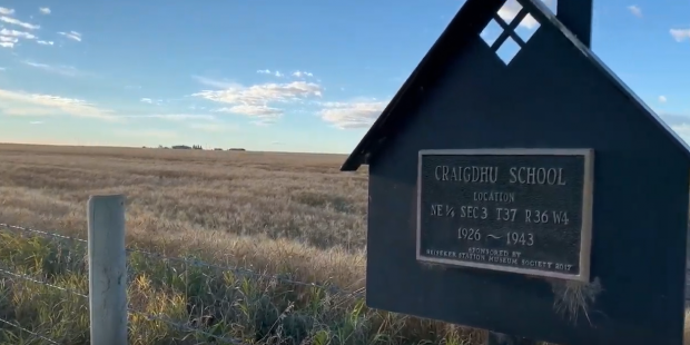 Sign in prairie field marking Craigduh School, 1926-1943.