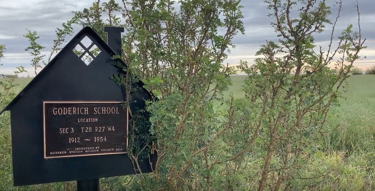 Sign in shrubs marking site of Goderich School, 1912-1954.