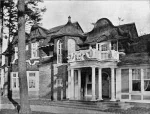 Black and white image of a Victorian house with a large balcony.