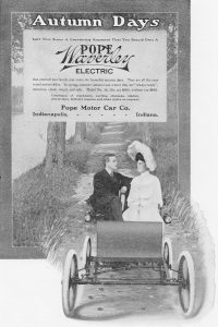 Publicité en noir et blanc montrant un homme et une femme conduisant une voiture électrique sur un chemin de campagne. Titre : Journées d’automne/ N'est-ce pas un argument convaincant pour acquérir une Pope Waverley électrique. 