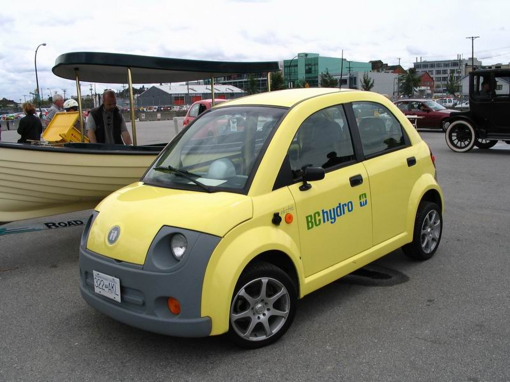 Colour photograph of a small, rounded four-seater car in a parking lot. Logo on the door reads “BC HYDRO”