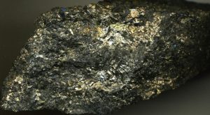Colour photograph of a chunk of stone with metal veins running through it.