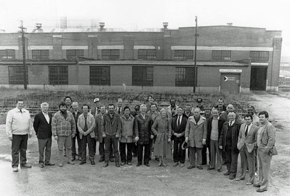 Photographie d’archive en noir et blanc avec environ 25 personnes posant devant la rotonde de la rue John.