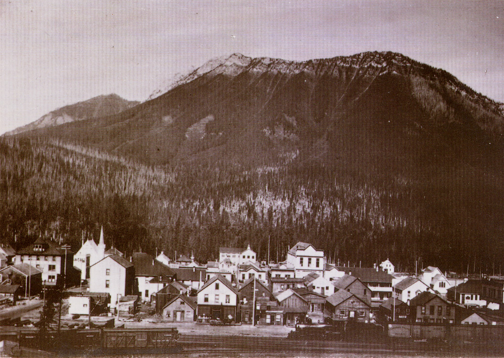 Townsite of Fernie, BC with the railway in front of shops and churches.