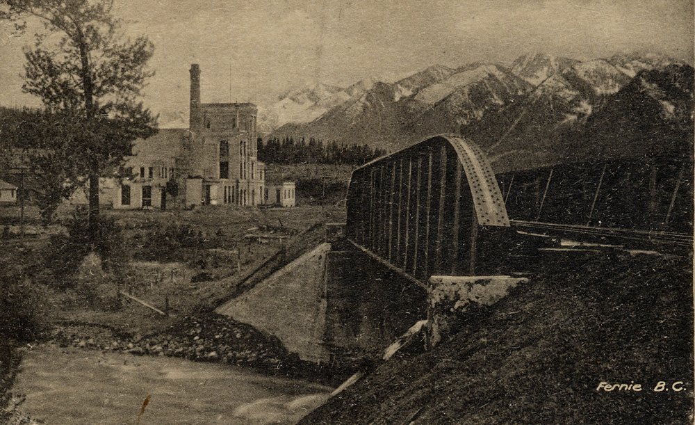 A railroad bridge across the Elk River in front of the large Ft Steele-Fernie Brewery building.