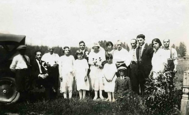 A wedding party with the bride and group standing in the middle.