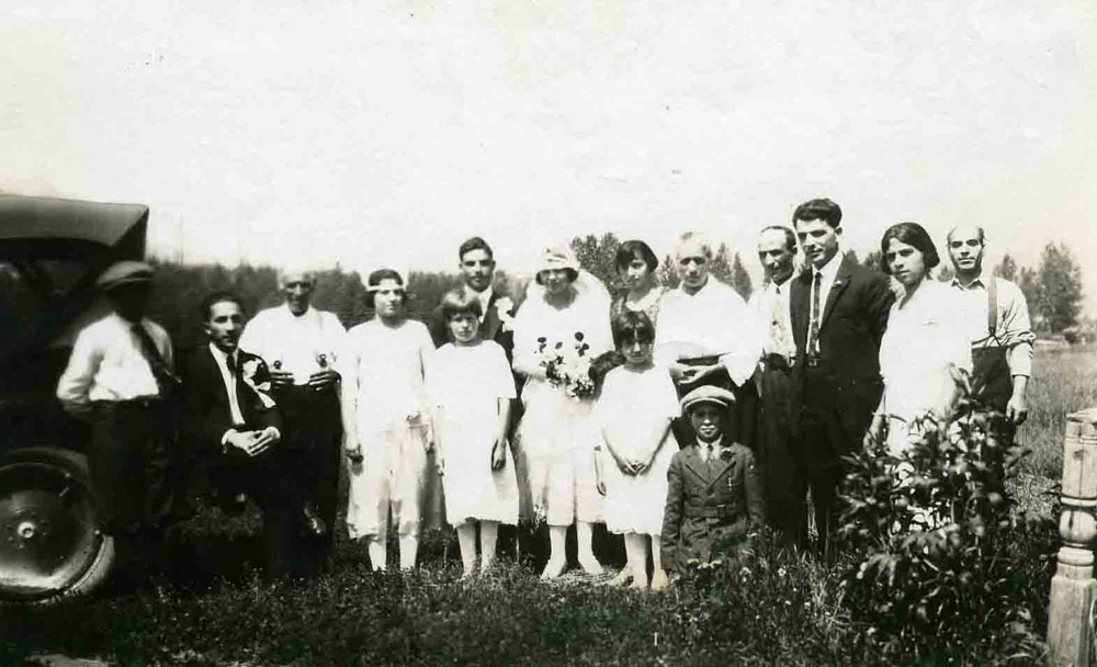 Une fête de mariage avec la mariée et le groupe debout au milieu.