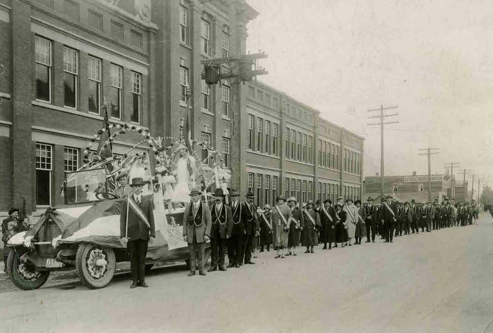 Parade float and procession in front of the Fernie Public School