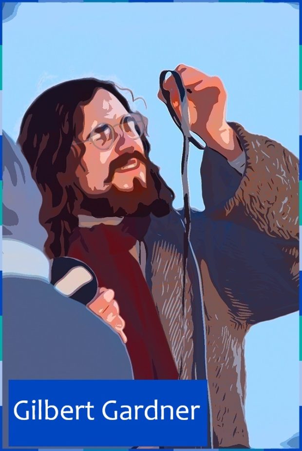 A photograph, edited to look like a comic strip, of a man with a beard and long brown hair. He is wearing a coat, a burgundy scarf, and small round glasses. He is examining a roll of film. On the lower left corner are the words: Gilbert Gardner.