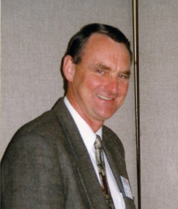 Man in a suit and tie smiles.