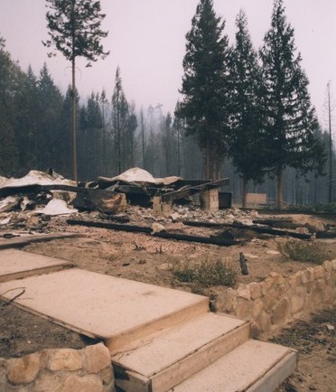 Une fondation en pierres, blocs de ciment et du métal tordu après le feu.