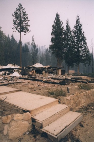 A stone foundation, concrete blocks, and twisted metal after the fire.