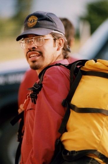 First Nations firefighter with a yellow backpack and wearing a blue ball cap.