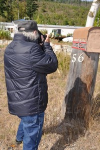 Photographe prenant une photo d'un boîte à lettres rurale.