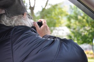 Un photographe prenant une photo assis dans son véhicule.