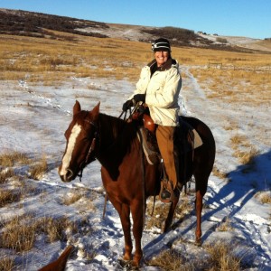 Femme assise sur un cheval sellé en hiver.