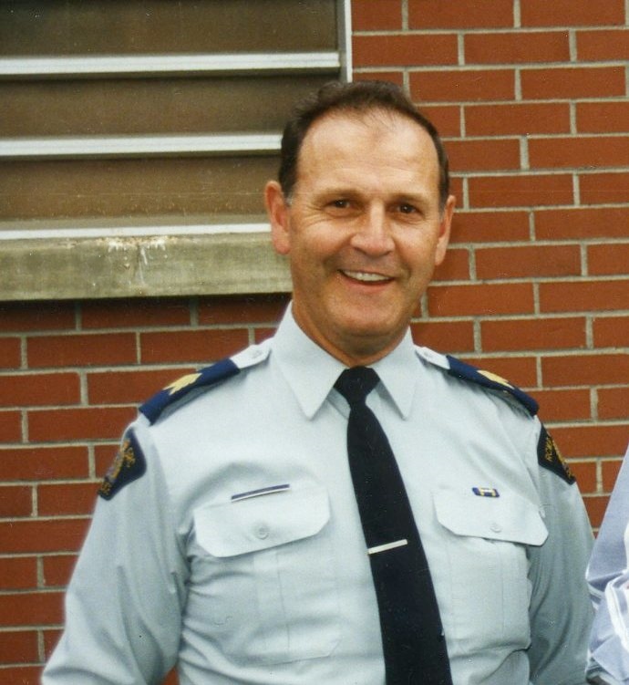 Man in police uniform smiles.