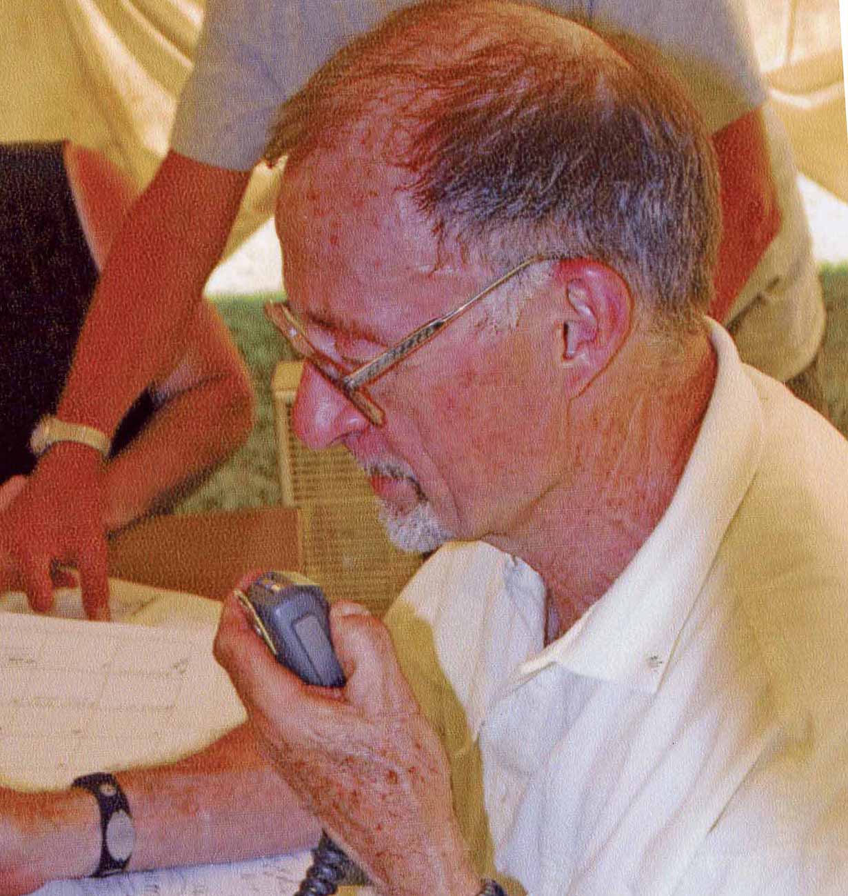 Portrait of a man speaking into a hand held radio speaker.