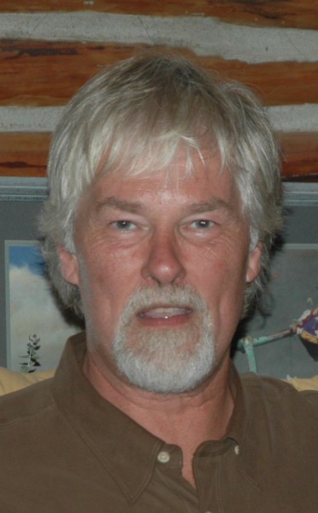 Portrait of a silver haired man with a goatee looking directly ahead.
