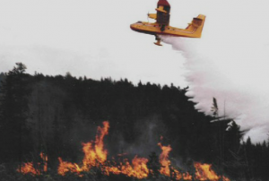 Feu et fumée dans les collines. Retardant rouge largué d'un avion. 