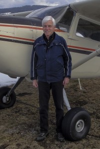Man stands beside a plane. Snow on ground.