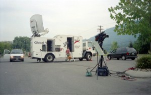 Television vehicle with satellite dish on roof.