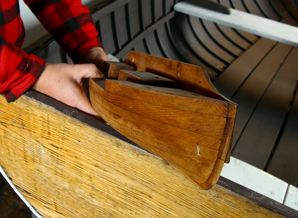 Color photograph of a wooden half hull, front view.