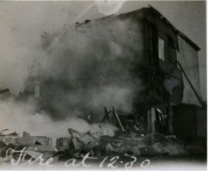 Black and white photograph of building on fire.