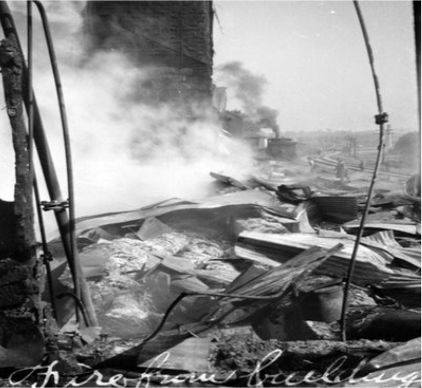 Pile of sheet metal debris with plumes of smoke rising.