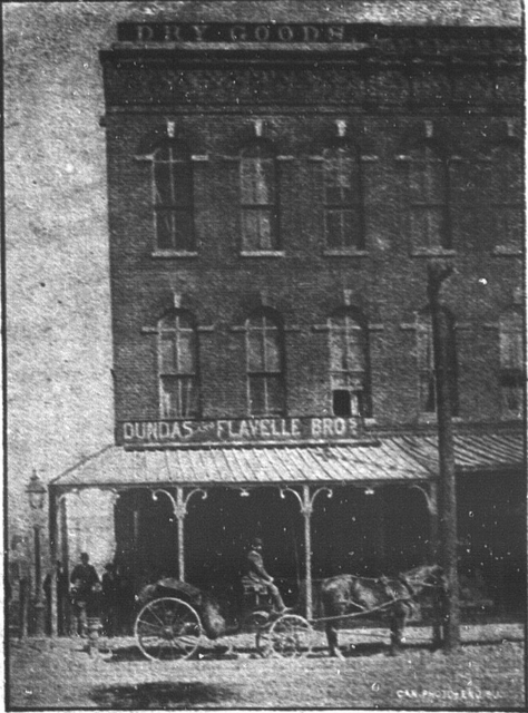 Three storey store front with wooden verandah.