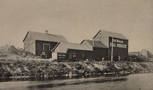 Wood framed building on the bank of a river.