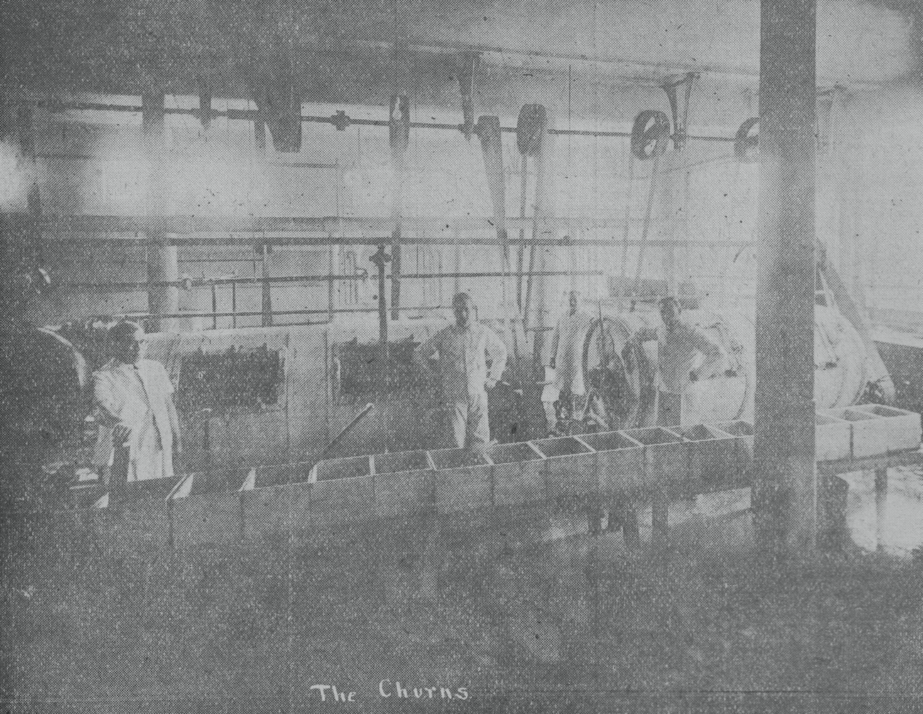 Black and white photograph of four men behind butter boxes.