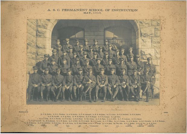 Group of military personnel standing in front of an entrance to a building.