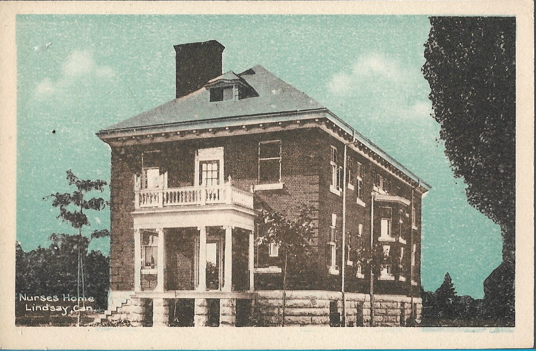 Red brick two storey building with a balcony.