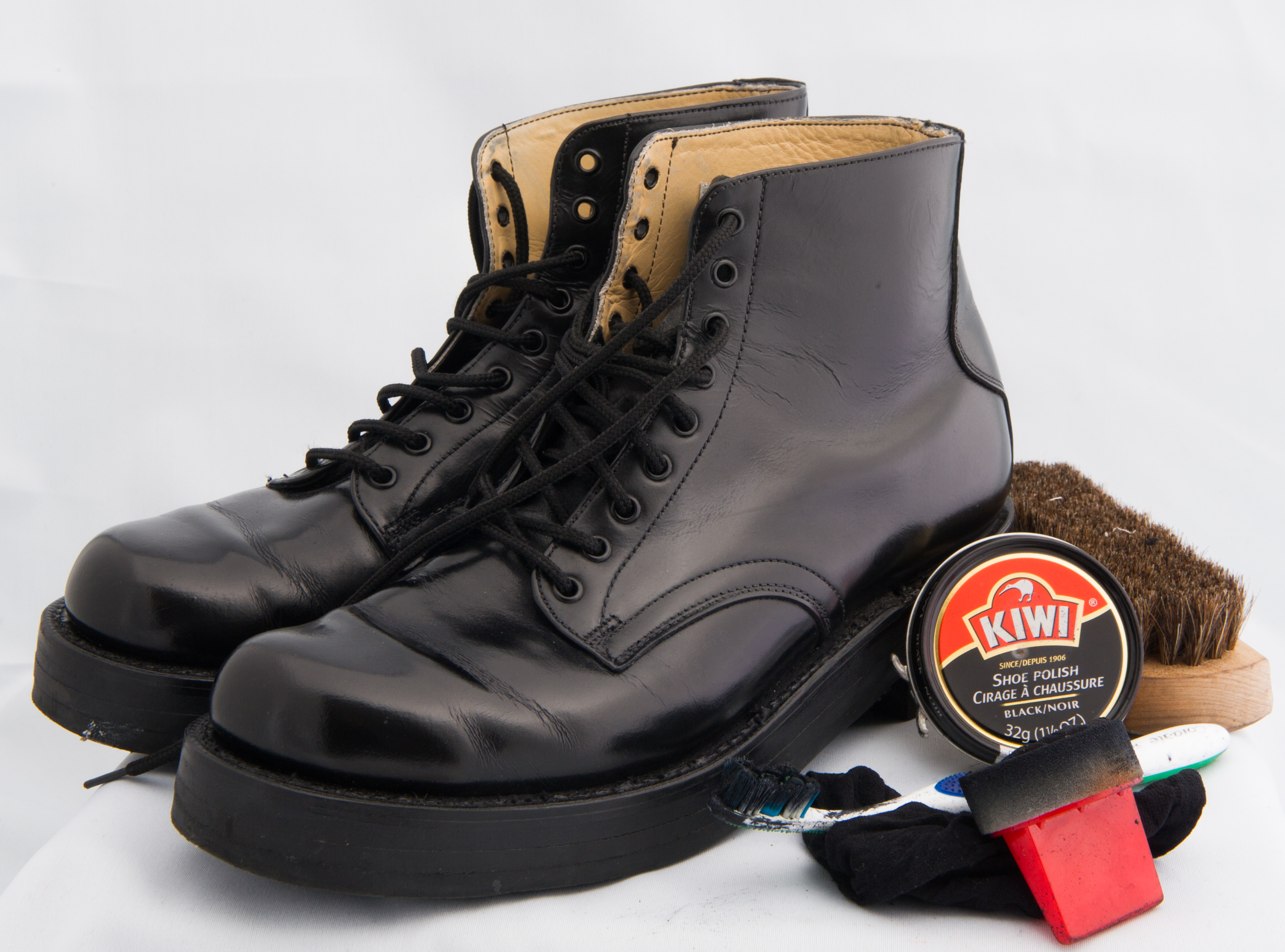 Black Honour Guard lace up boots and polishing kit, with Kiwi polish in round container, and red brush.
